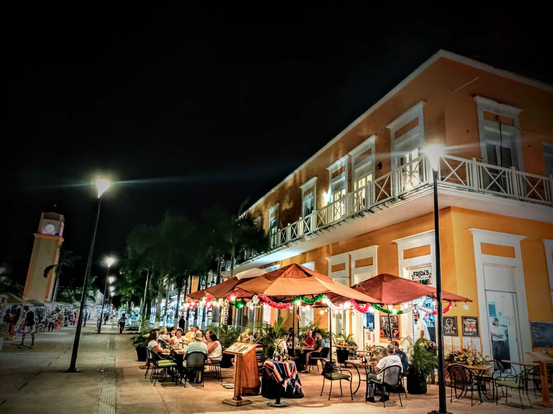 exterior of Mexican restaurant with tables and umbrellas at night