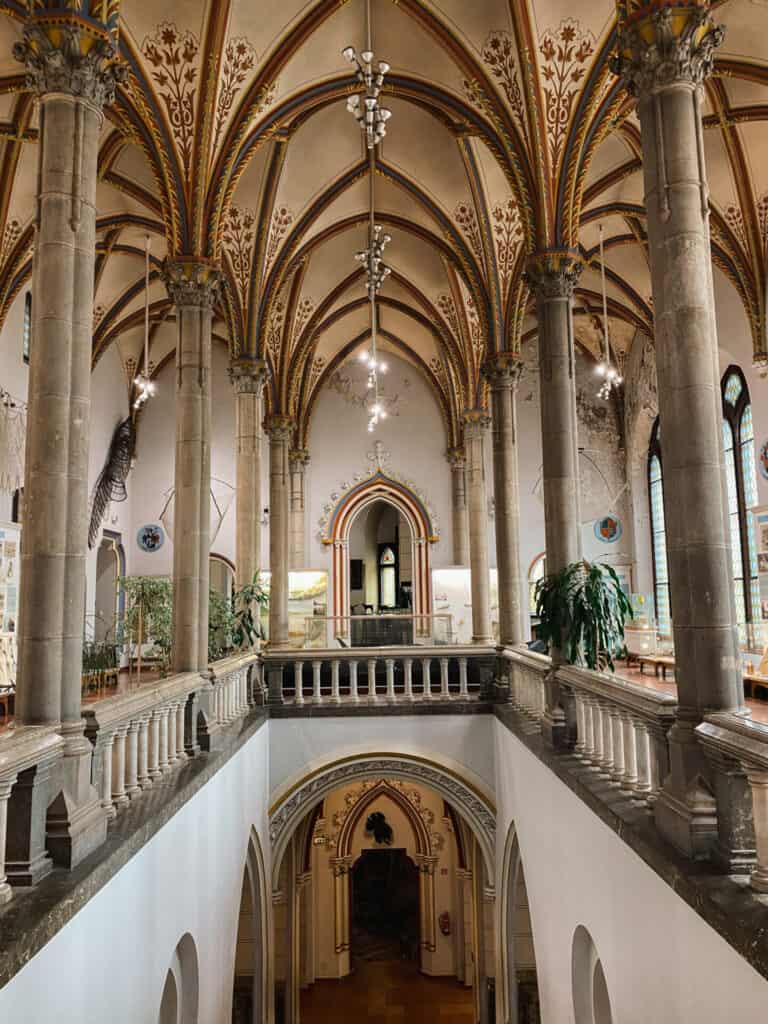 high ceiling museum with grandiose arches and balcony