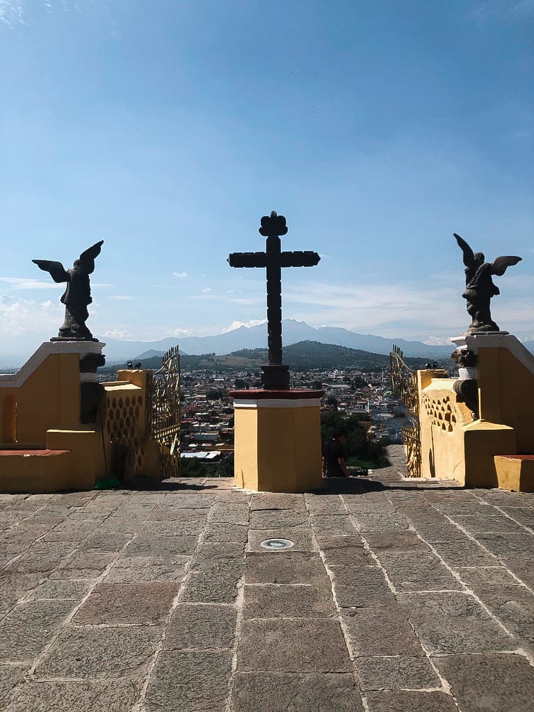 cross statue flannked by two angel statues outdoors