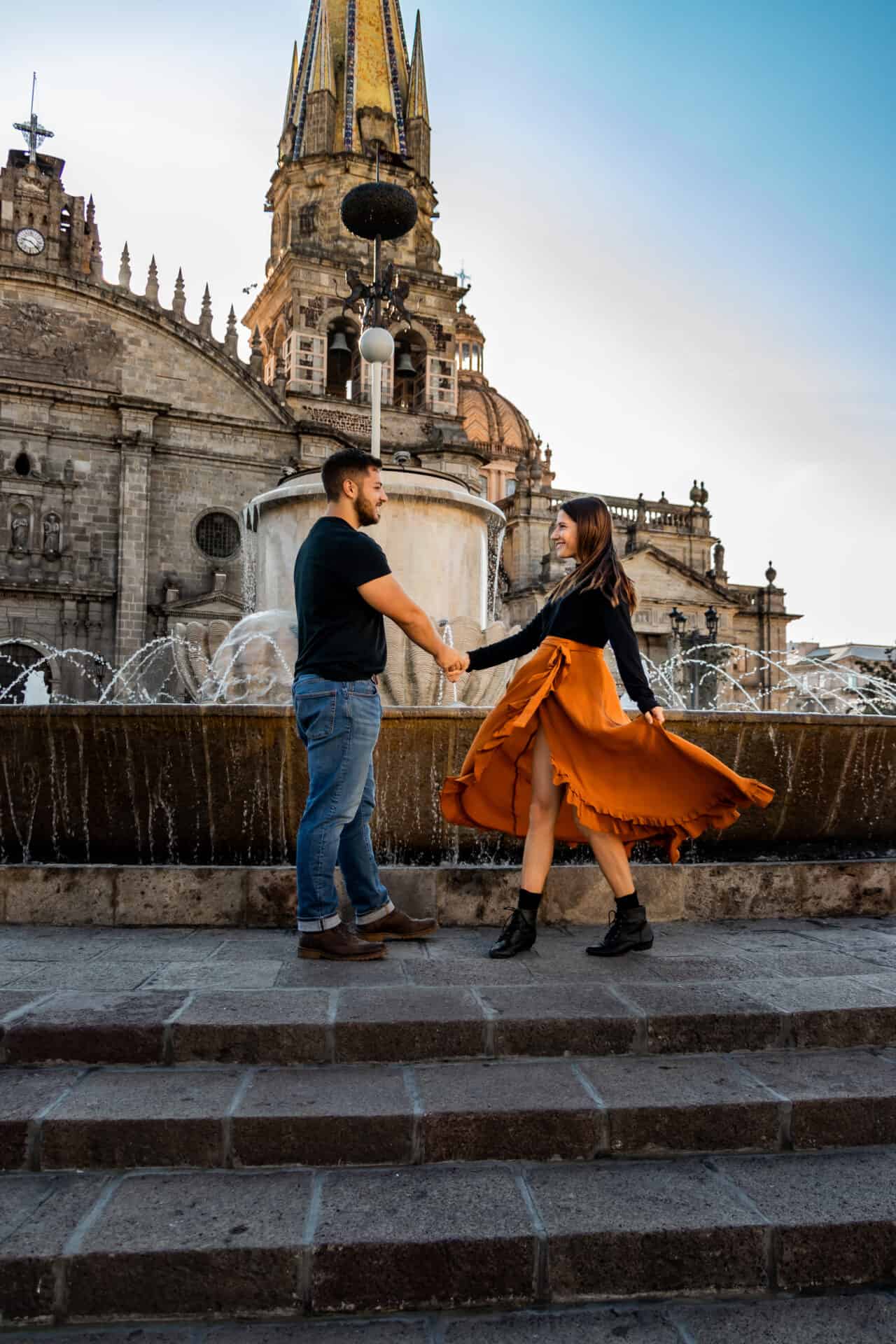 couple in black dancing in front of a fountain