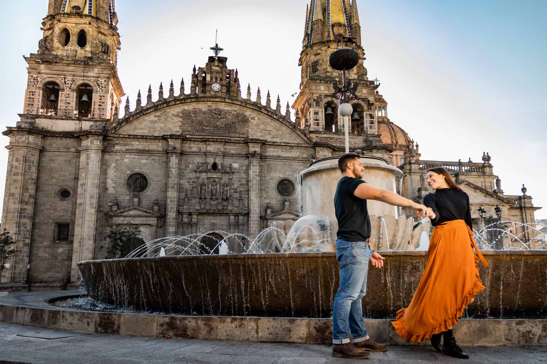 couple in black dancing in front of a fountain