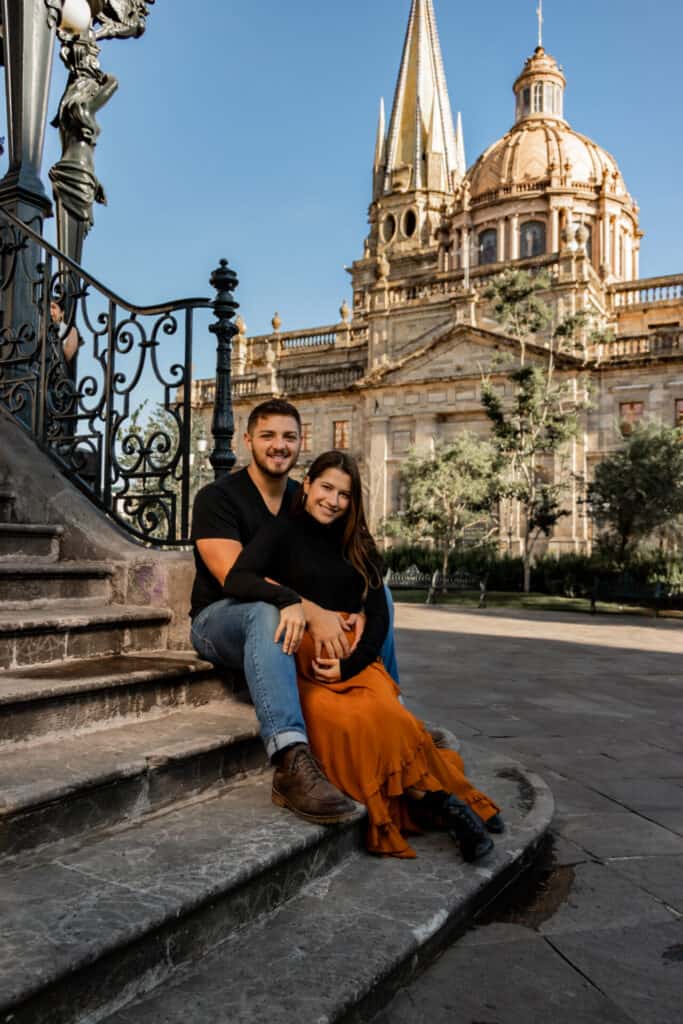couple in black embracing on steps in front of gorgeous cathedral during daytime