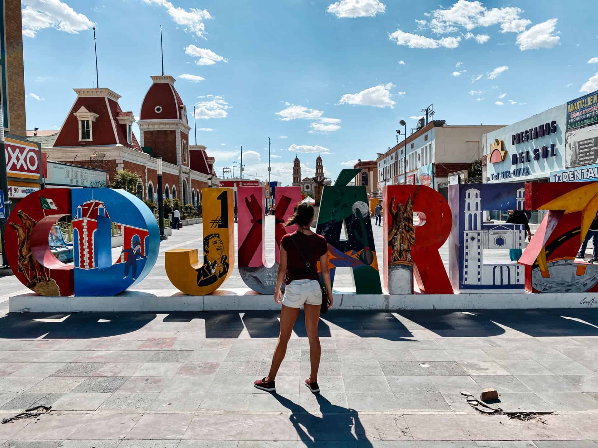 woman standing in front of juarez sign