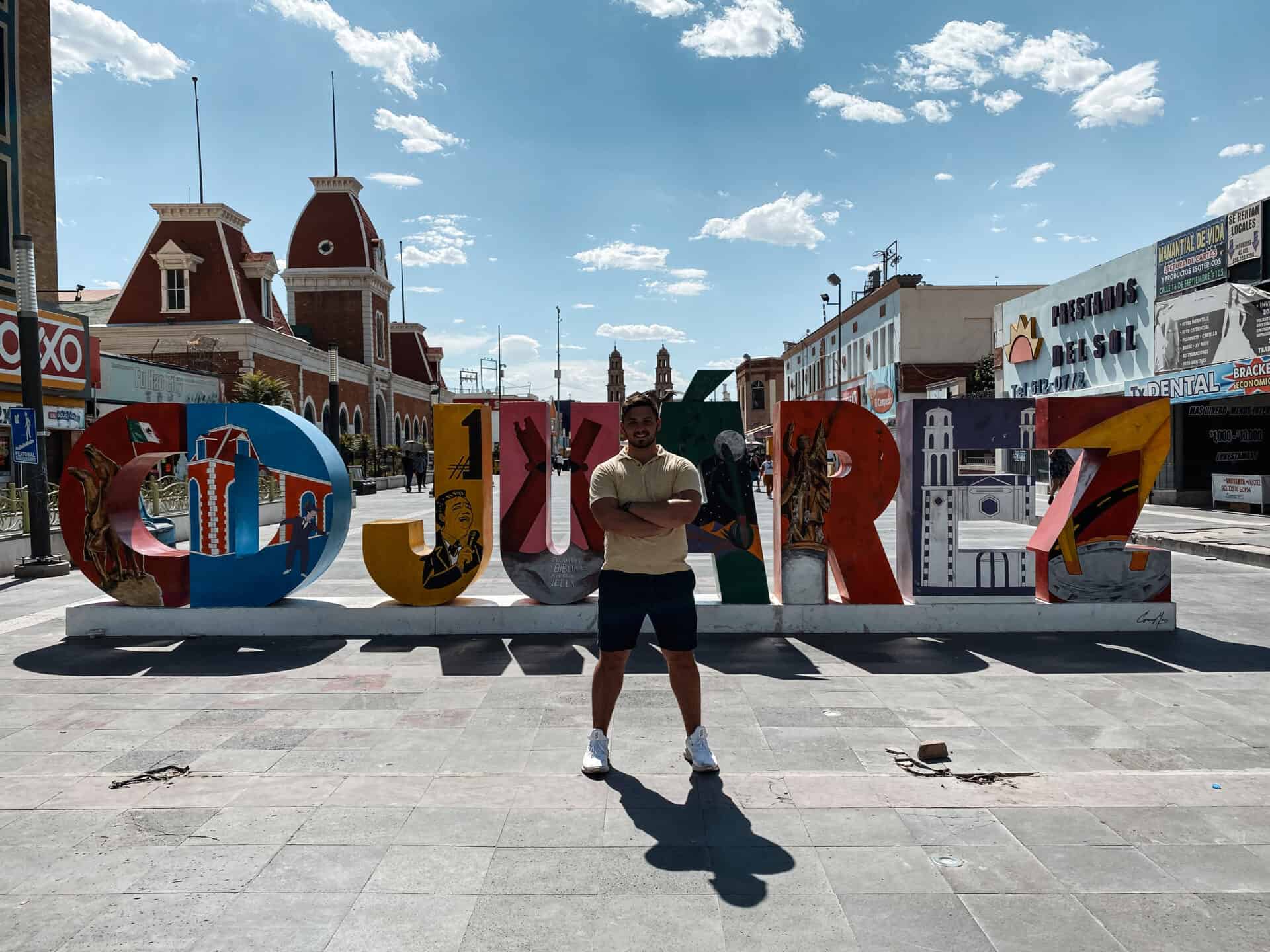 man standing in the center of juarez sign