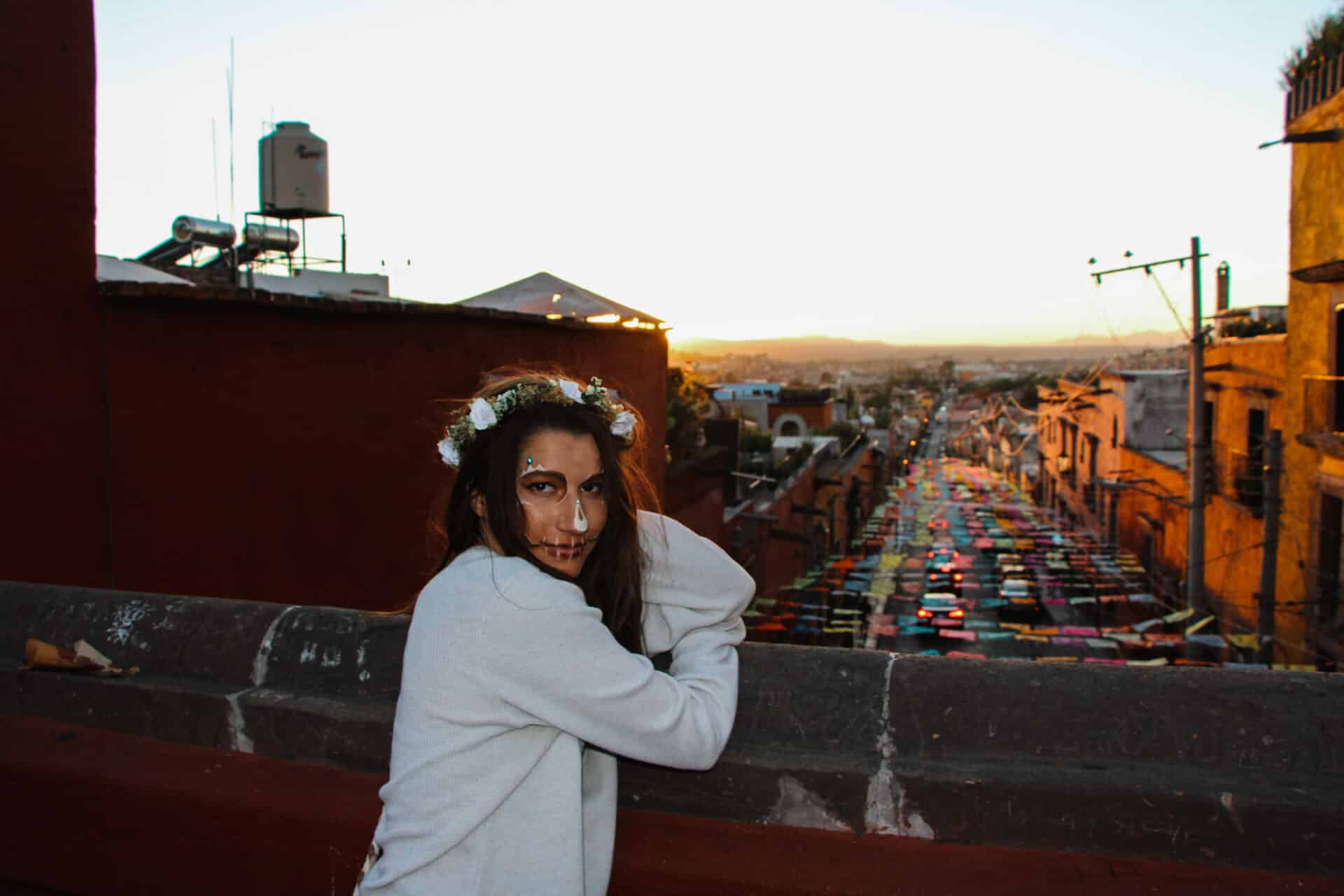 woman in flower crown overlooking a mexican bridge at sunset