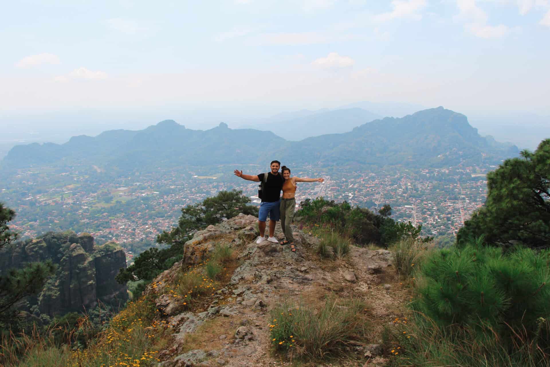 man and woman on tepotzlan mountain overlooking mexican town