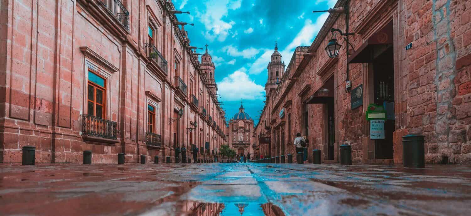 Puddle with reflection of pink cathedral in Morelia Mexico