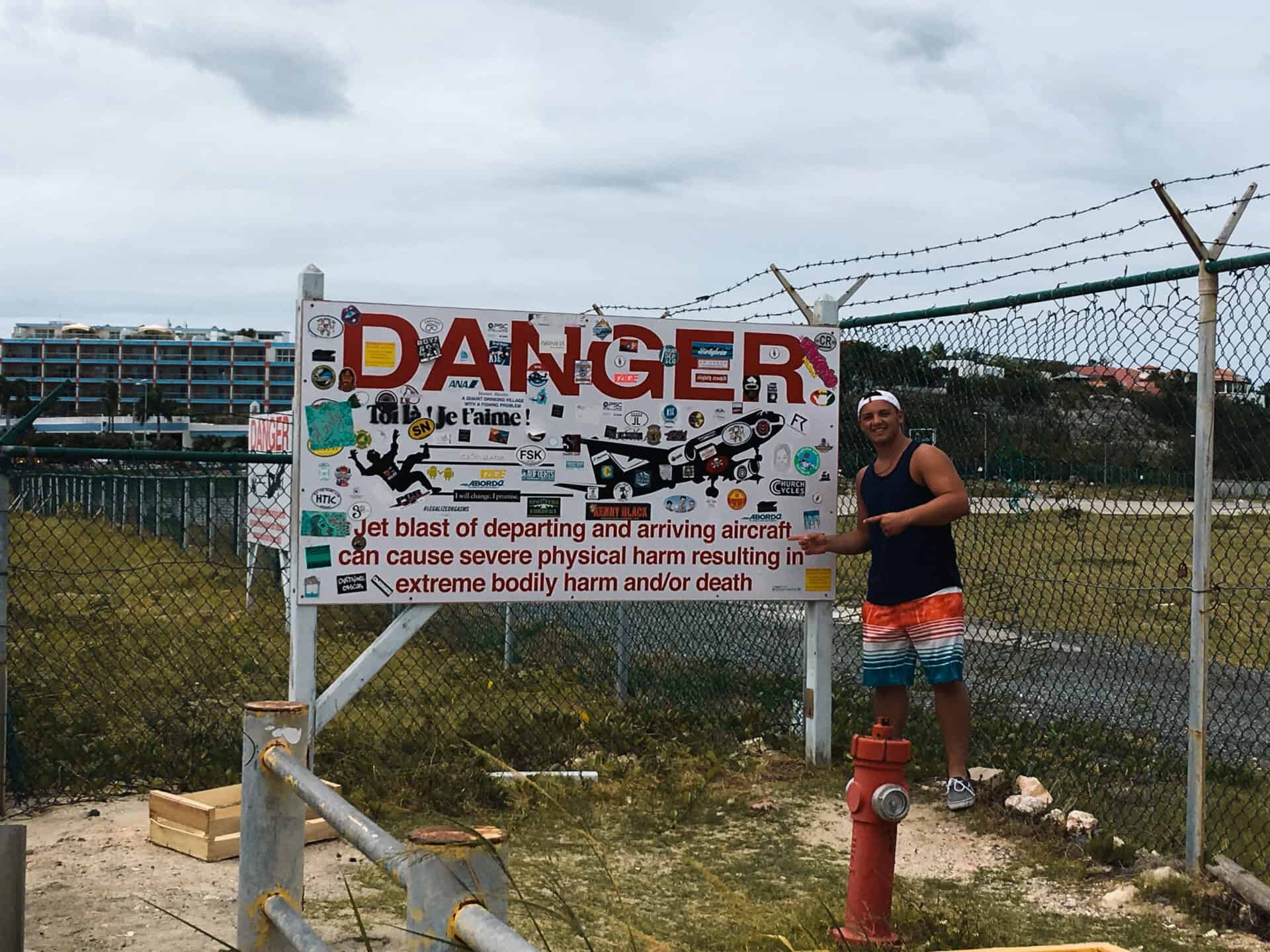 Man standing in front of danger sign