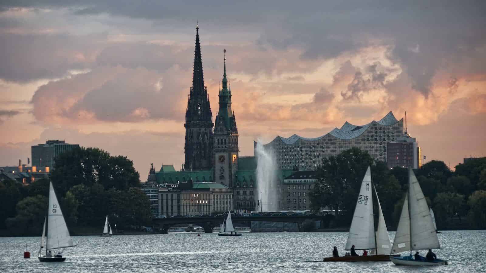 German City on a river during dusk with sailboats and kayaks on the water
