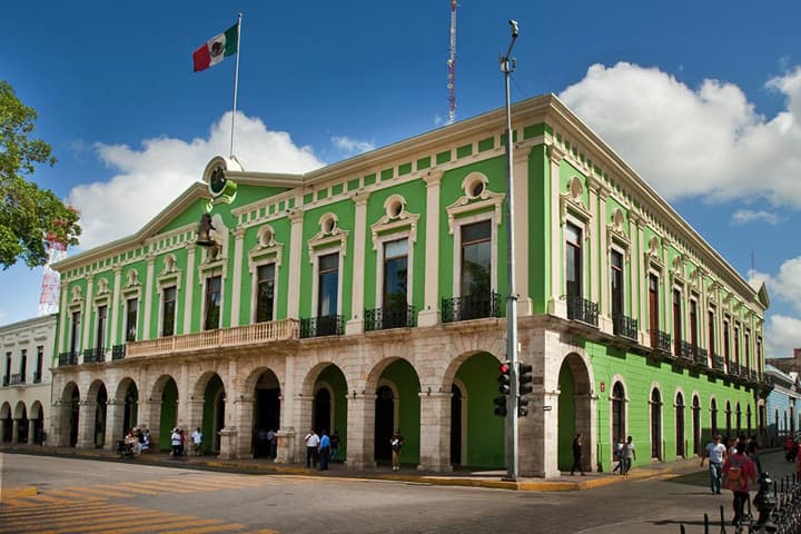 green colonial building on the corner of a mexican city