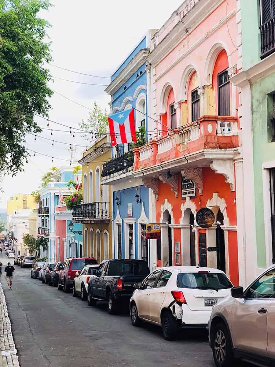 cars parked at one side of street with colorful buildings in san juan