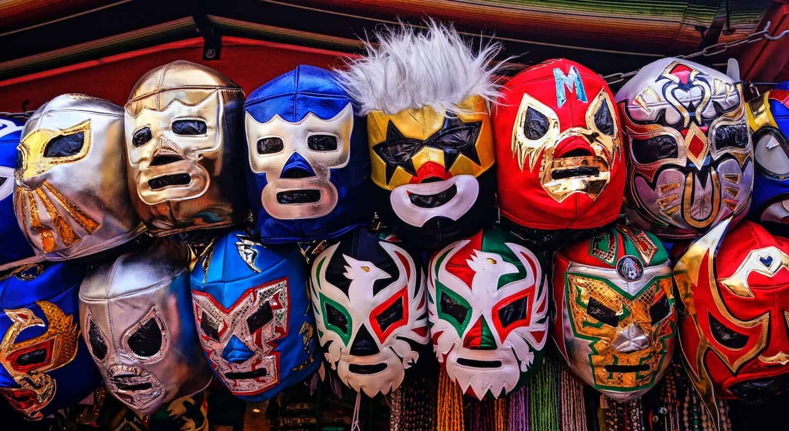 assorted-color of mexican wrestling masks hangeing on a wall