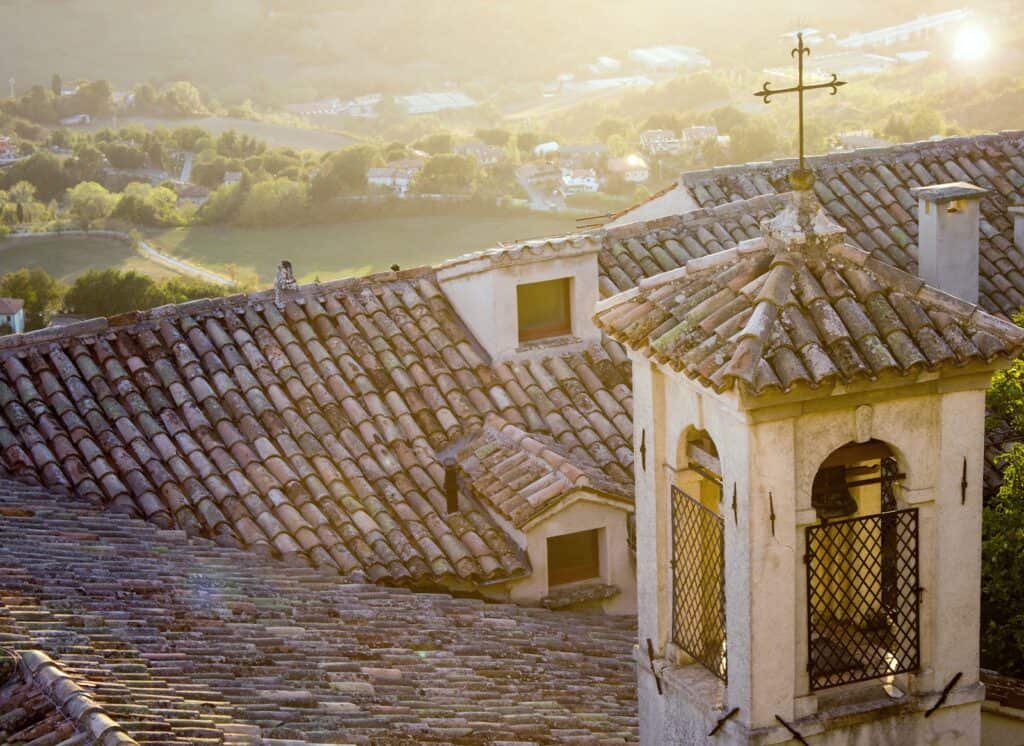 brown concrete Italian church steeple with cross during daytime