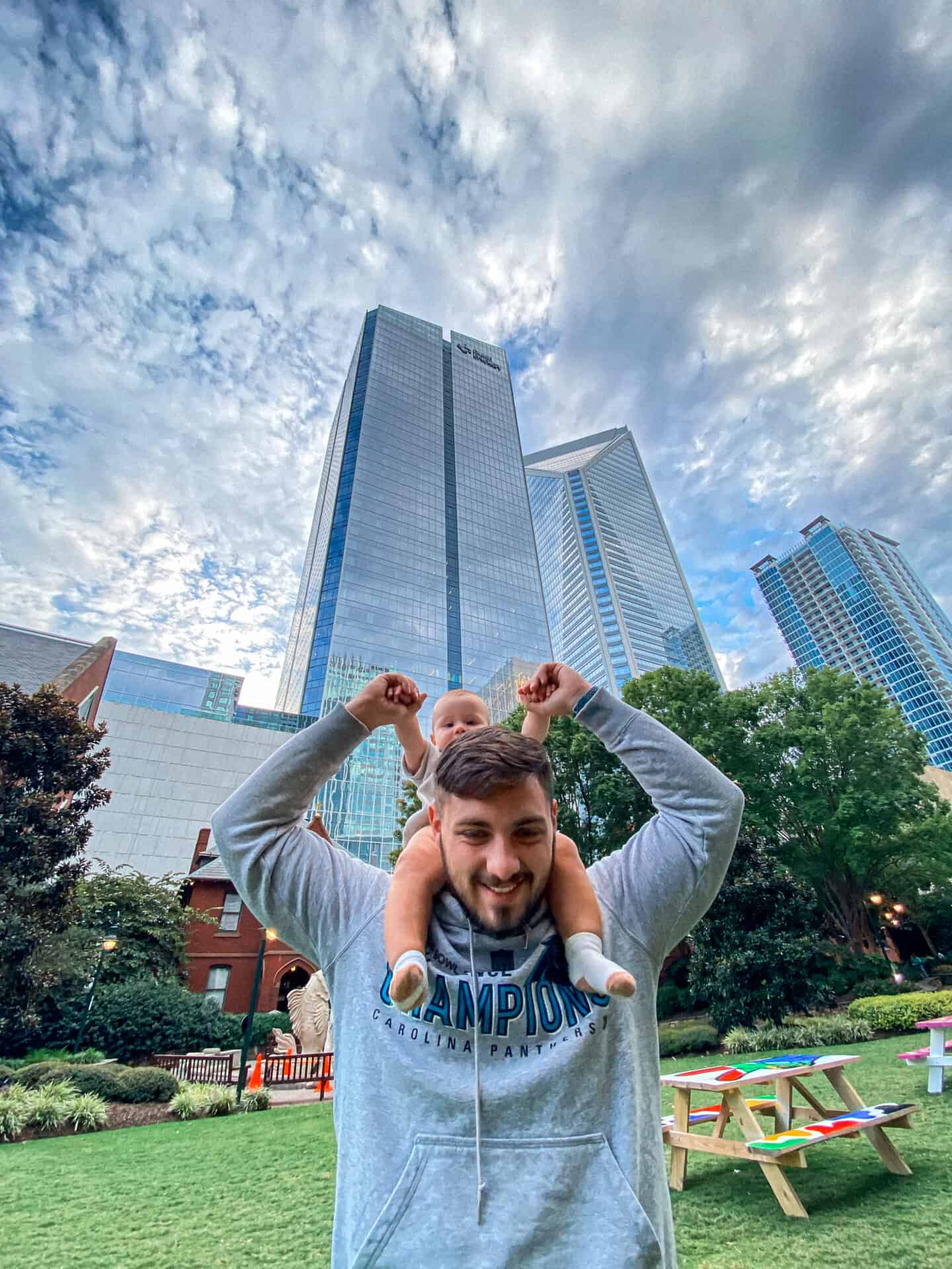 father with 8 month old child on shoulders in the middle of downtown charlotte