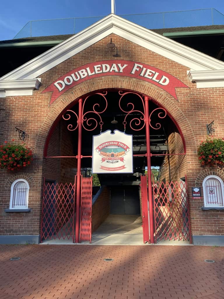 Entrance to brick baseball stadium with red iron gates