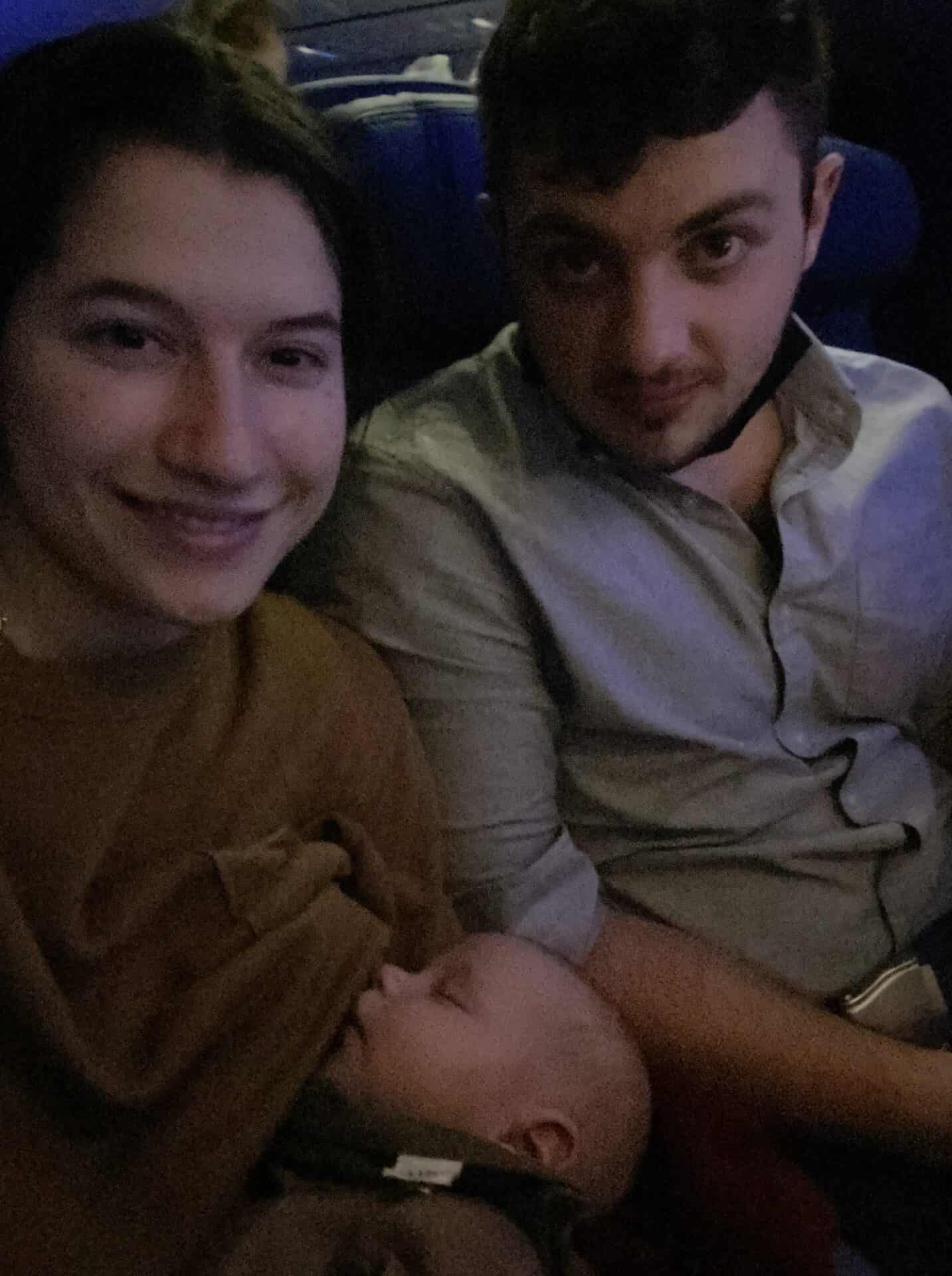 selfie of couple and sleeping baby in airplane