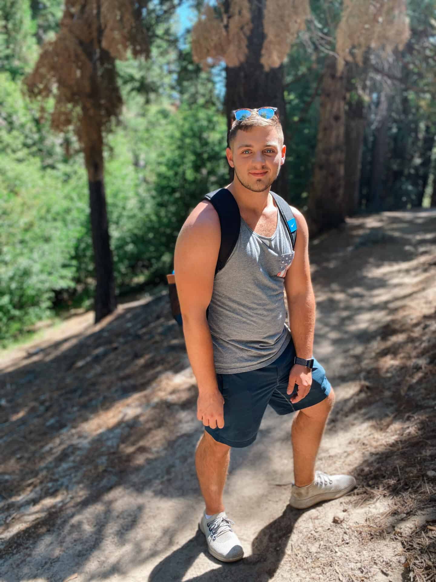 sexy father in tank top hiking through the American forest