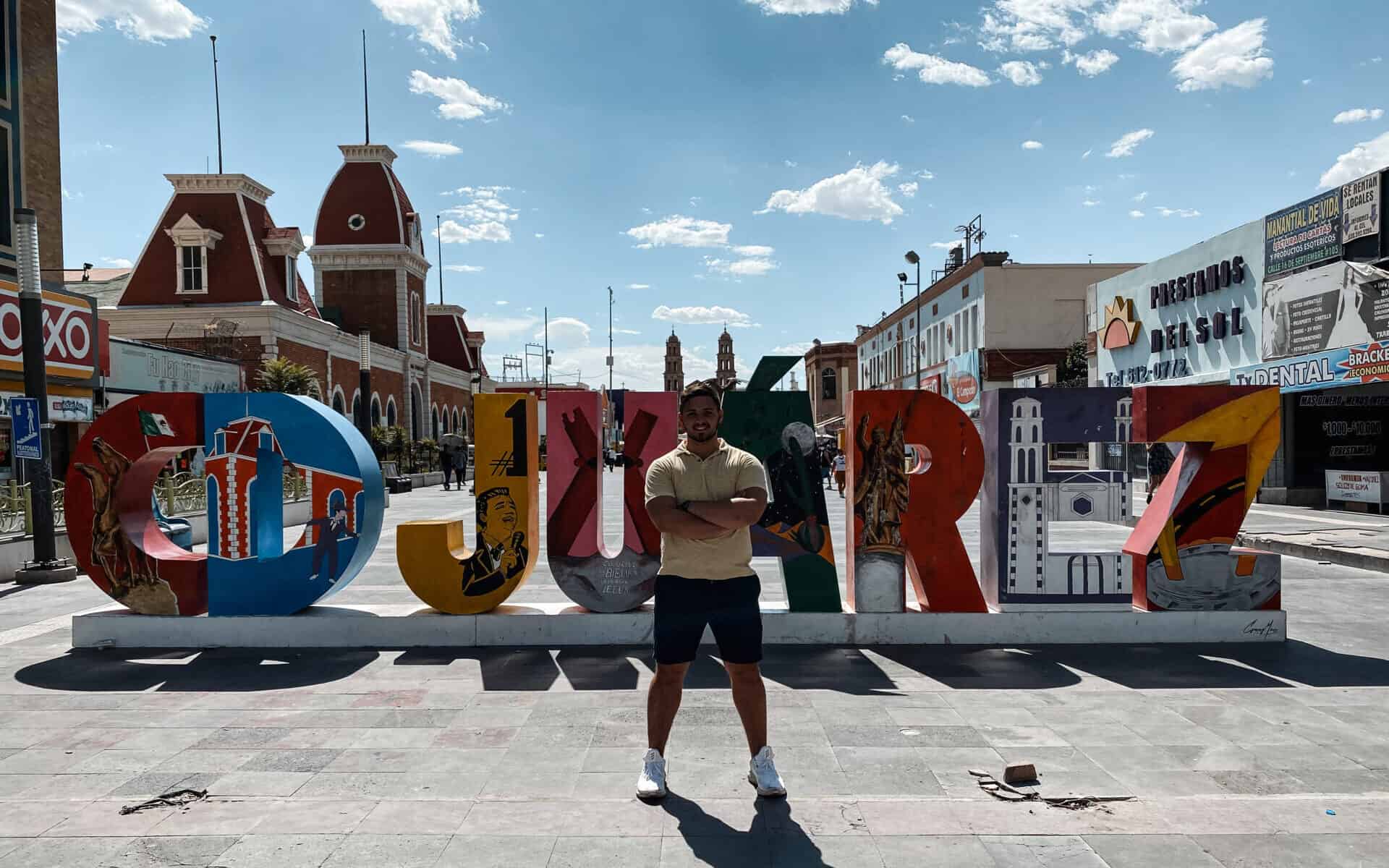 man standing in the center of juarez sign