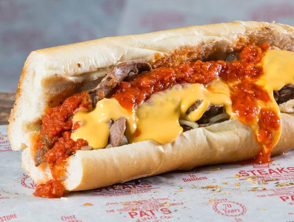 juicy cheesesteak with yellow cheese and red sauce