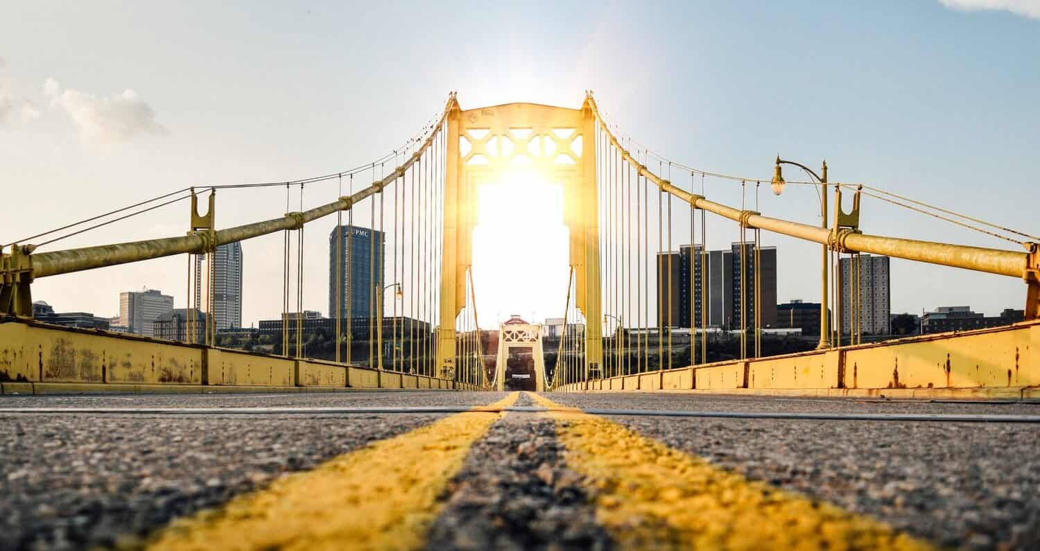 Sun shining through a yellow bridge in Pittsburgh