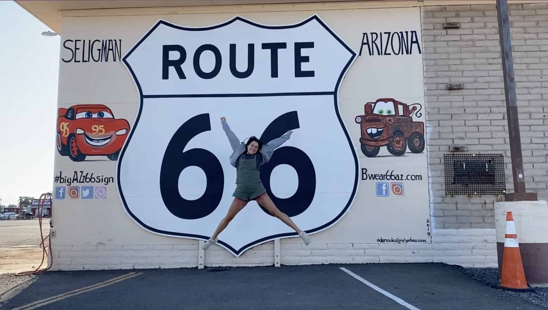 woman jumping in front of Route 66 mural