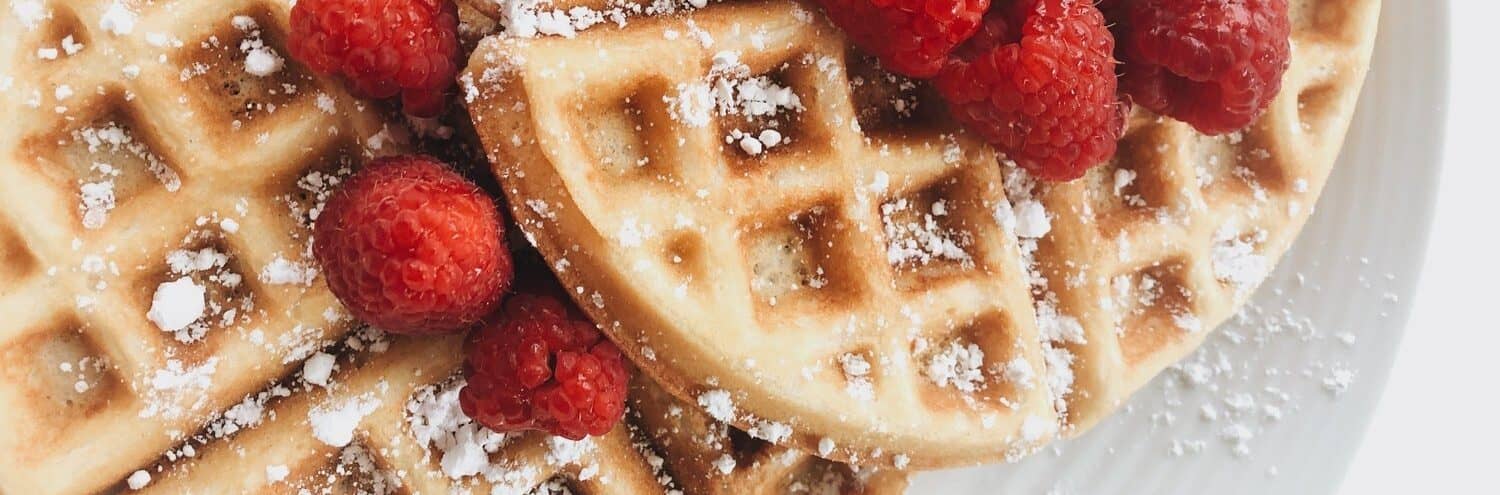 Raspberries garnished on waffles with powdered sugar