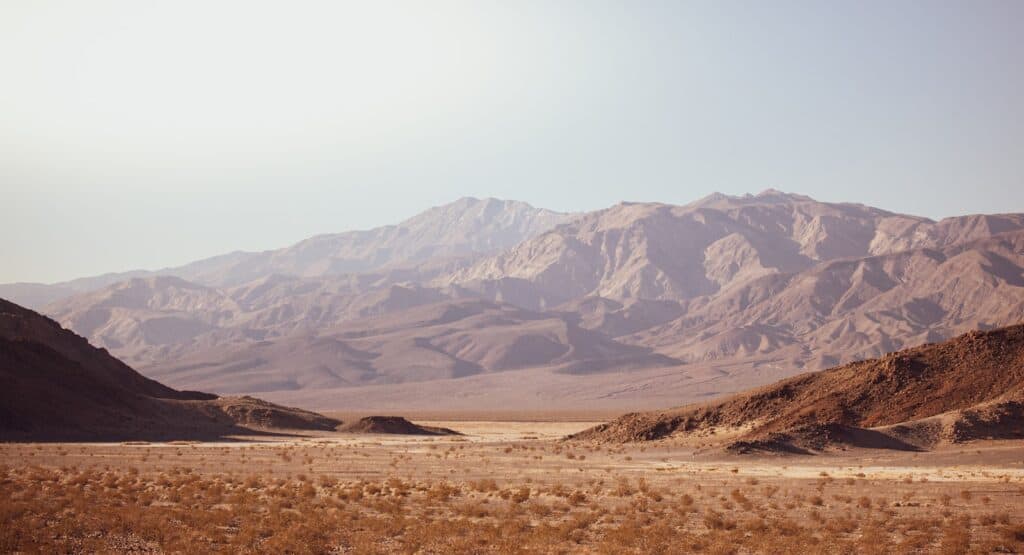 brown and gray mountains under white sky in death valley during daytime