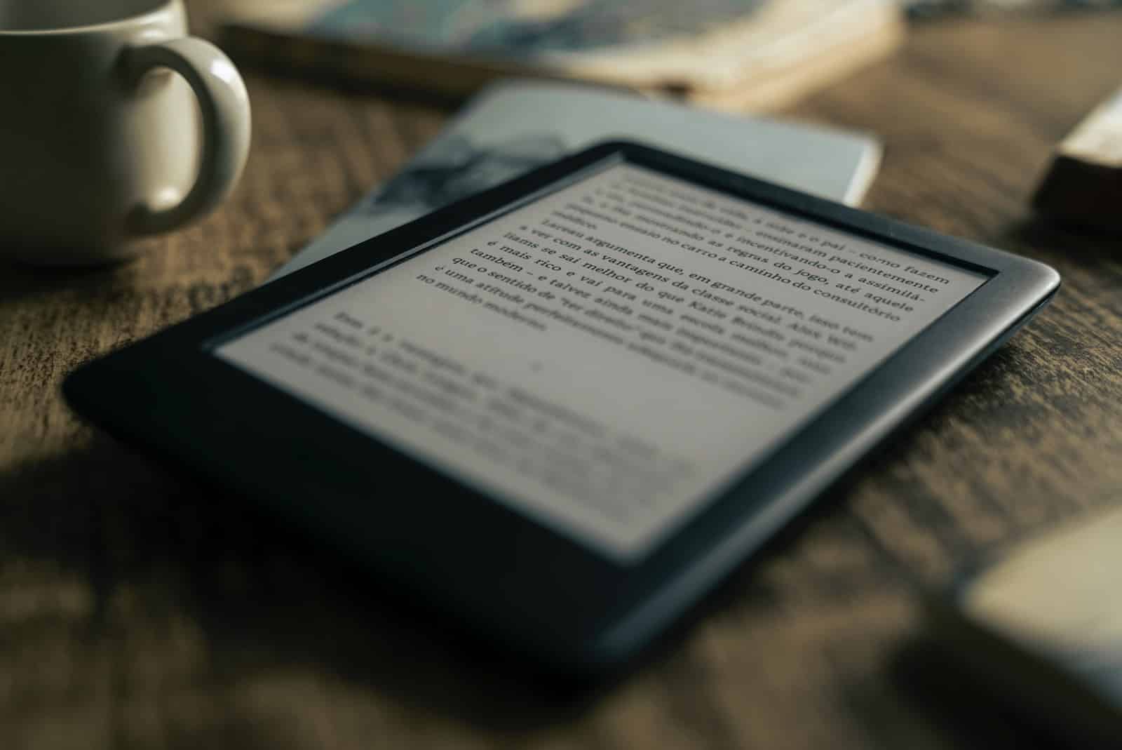 black kindle paperwhite on brown wooden table