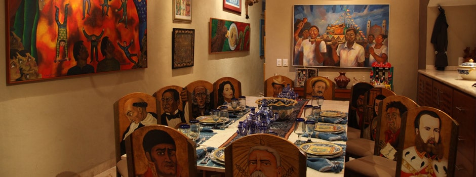 dinner table with colorful portraits painted on the chairs