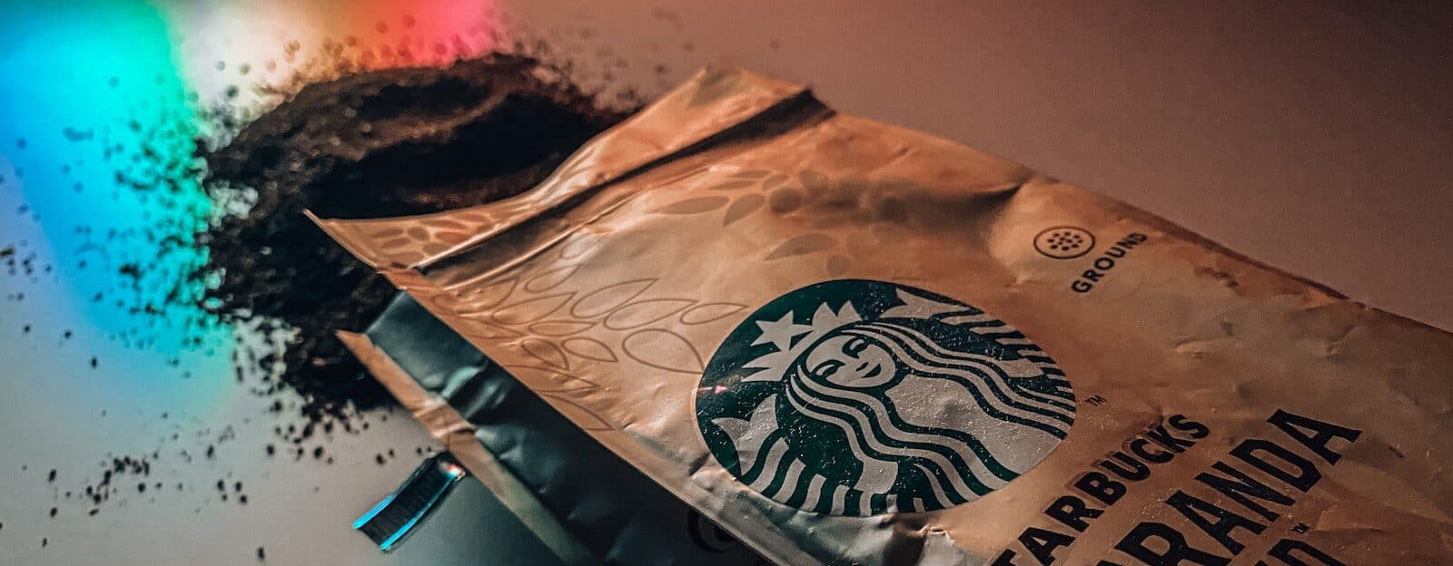 coffee grounds spilling out of brown starbucks coffee bean paper bag