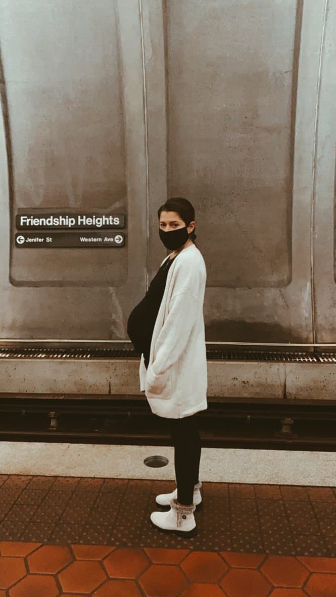pregnant woman in beige cardigan standing in DC metro station