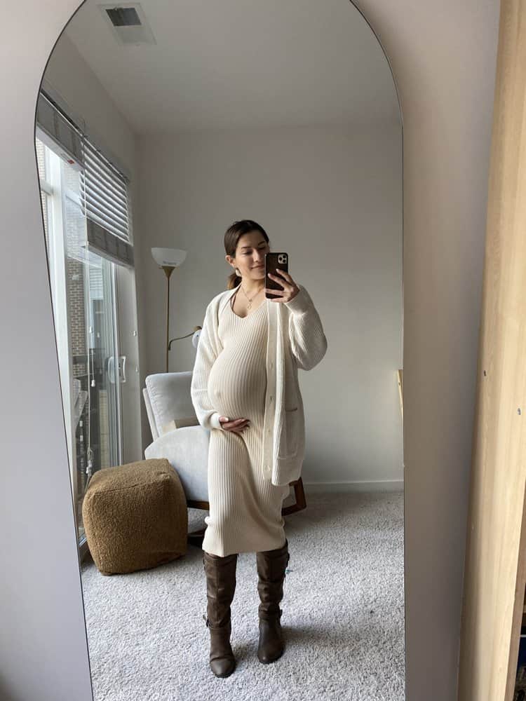 nine months pregnant woman in long white body dress, cardigan and brown boots