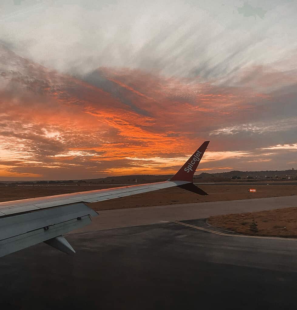 silhouette view of airplane wing during sunset