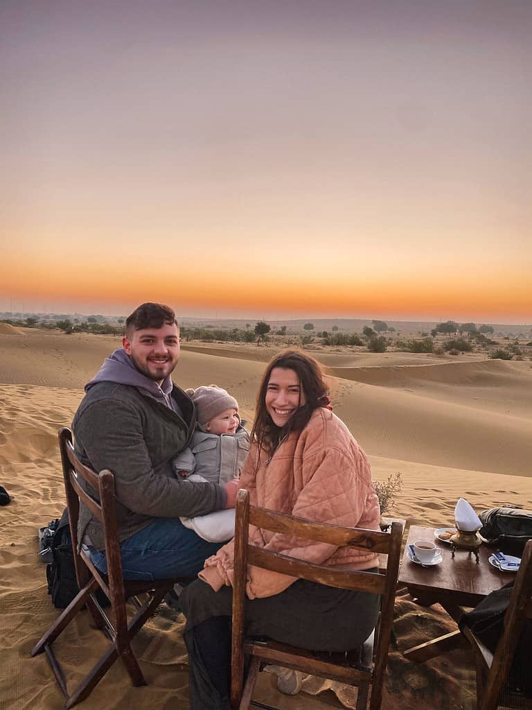 couple with child on lap enjoying sunrise tea in the Thar desert