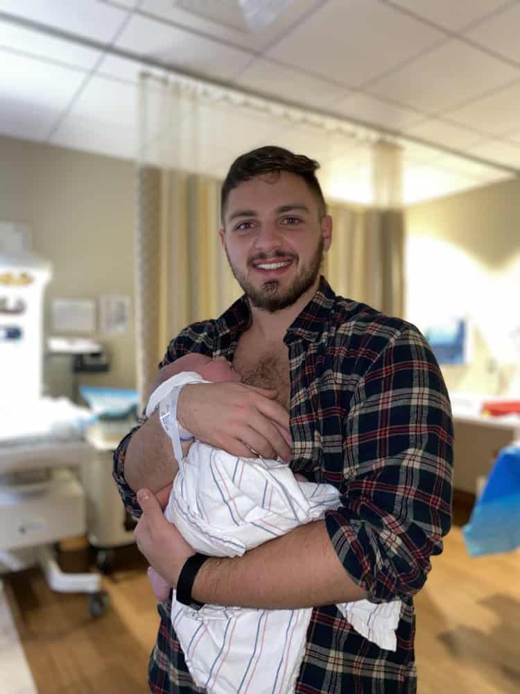 first time father holding his first born son on his chest in the hospital