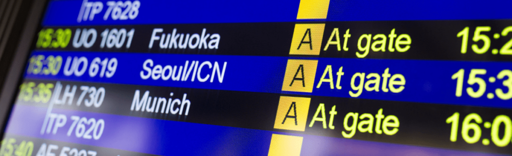 an airport screen with flight numbers listed