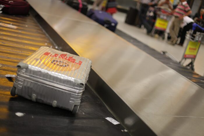 gray hardside luggage on conveyer belt