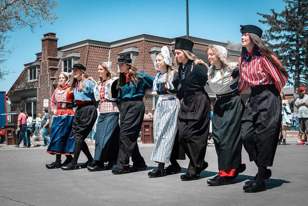 young dutch girls line dancing on the street in traditional dutch costumes