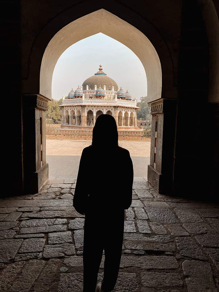 silhouette of woman at indian temple between a doorway arch