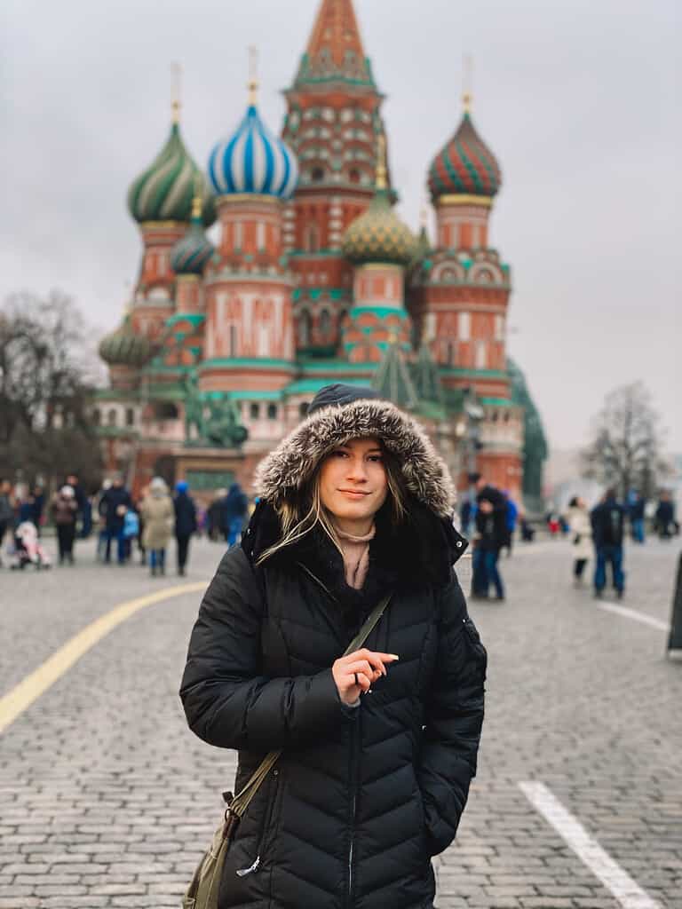woman in winter jacket standing in front of St Basils Russian Orthodox in moscow on a winter day