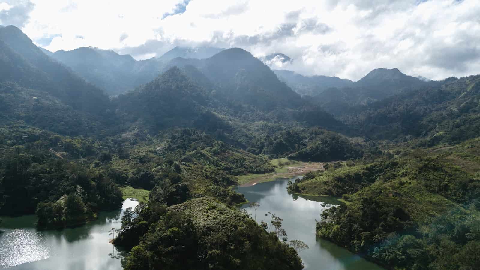 is it safe to travel to honduras on a cruise green mountains and river under white clouds during daytime