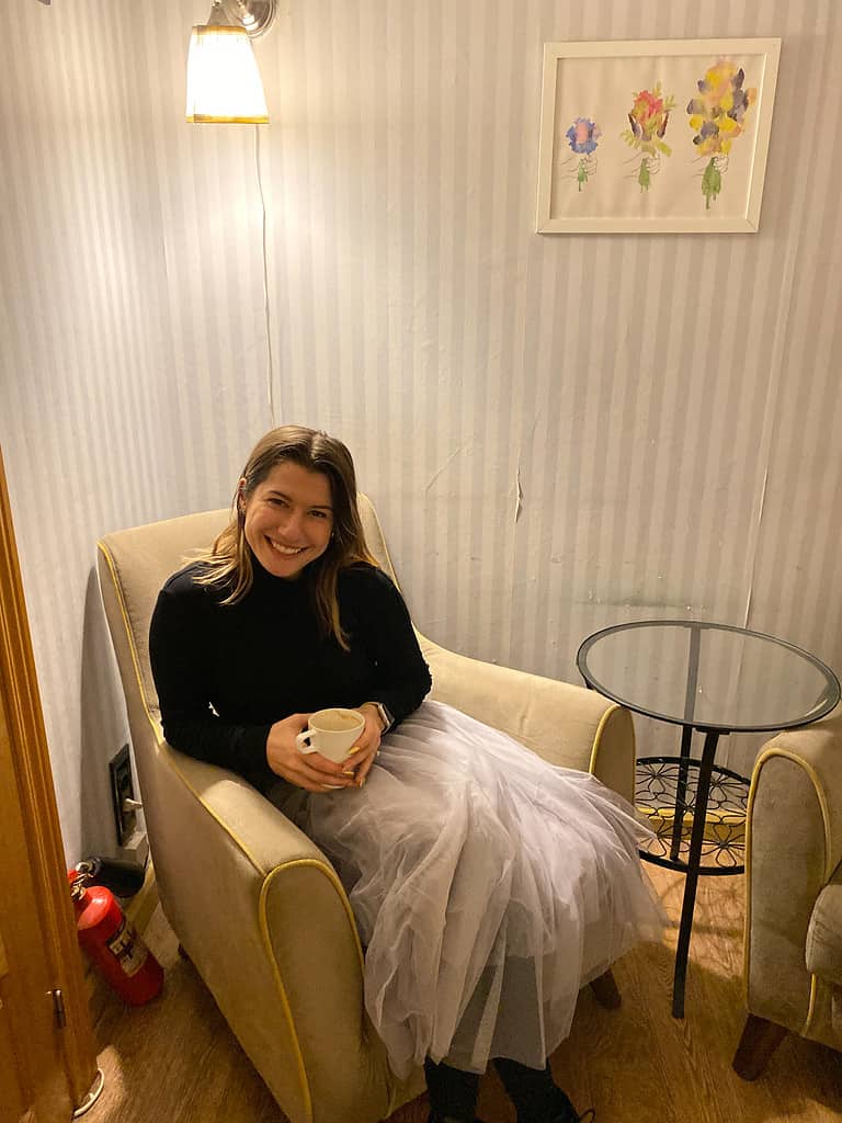 woman sitting in cozy corner with a cup of coffee