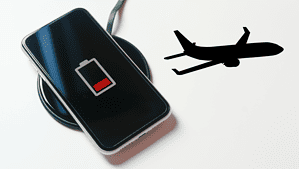 a black phone charging on a charging pad with an outline of a black plane