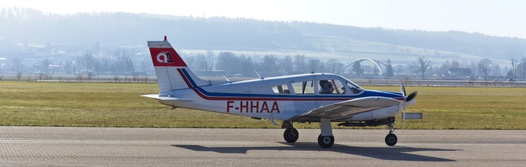 red and white cessna airplane on gray concrete ground during daytime