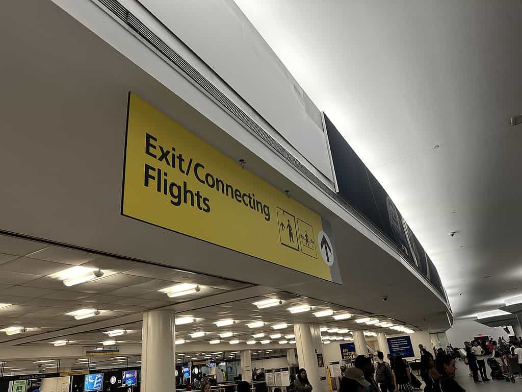 yellow sign directing to connecting flights in airport