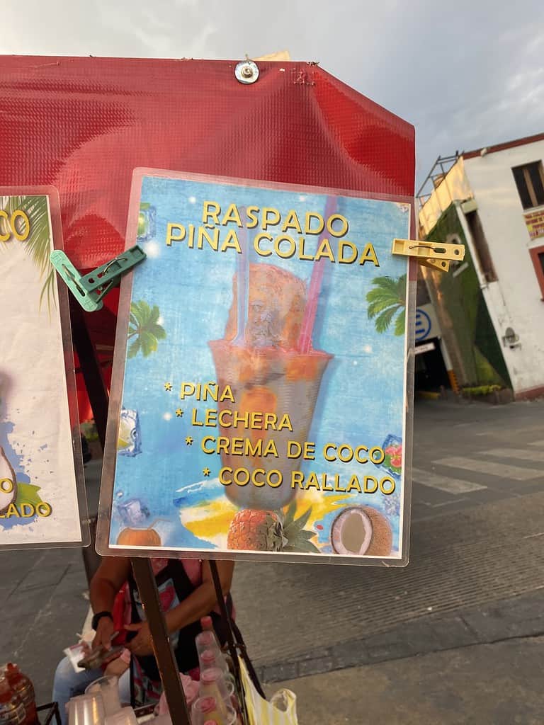 mexican sign with pink raspado pina colada drink in the streets of mexico