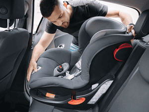 father in black shirt installing a carseat into a car